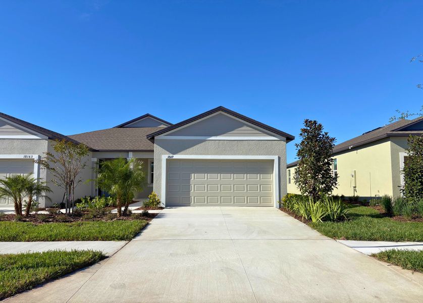 Front exterior of a new home in Angeline: The Villas, Land O' Lakes, FL, highlighting curb appeal (Image 1).