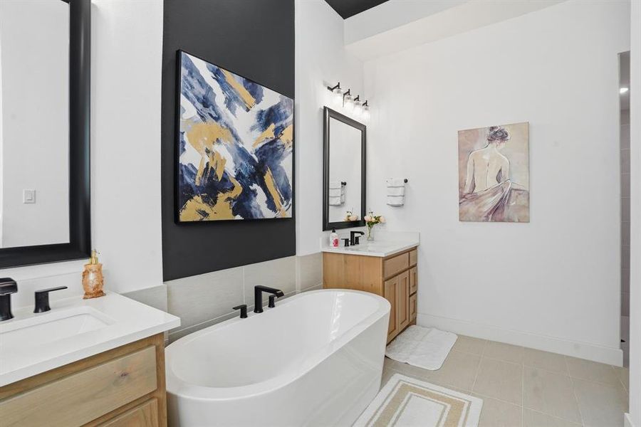 Full bathroom with two vanities, a freestanding bath, and light tile patterned floors Full bathroom with two vanities, a freestanding bath, and light tile patterned floors