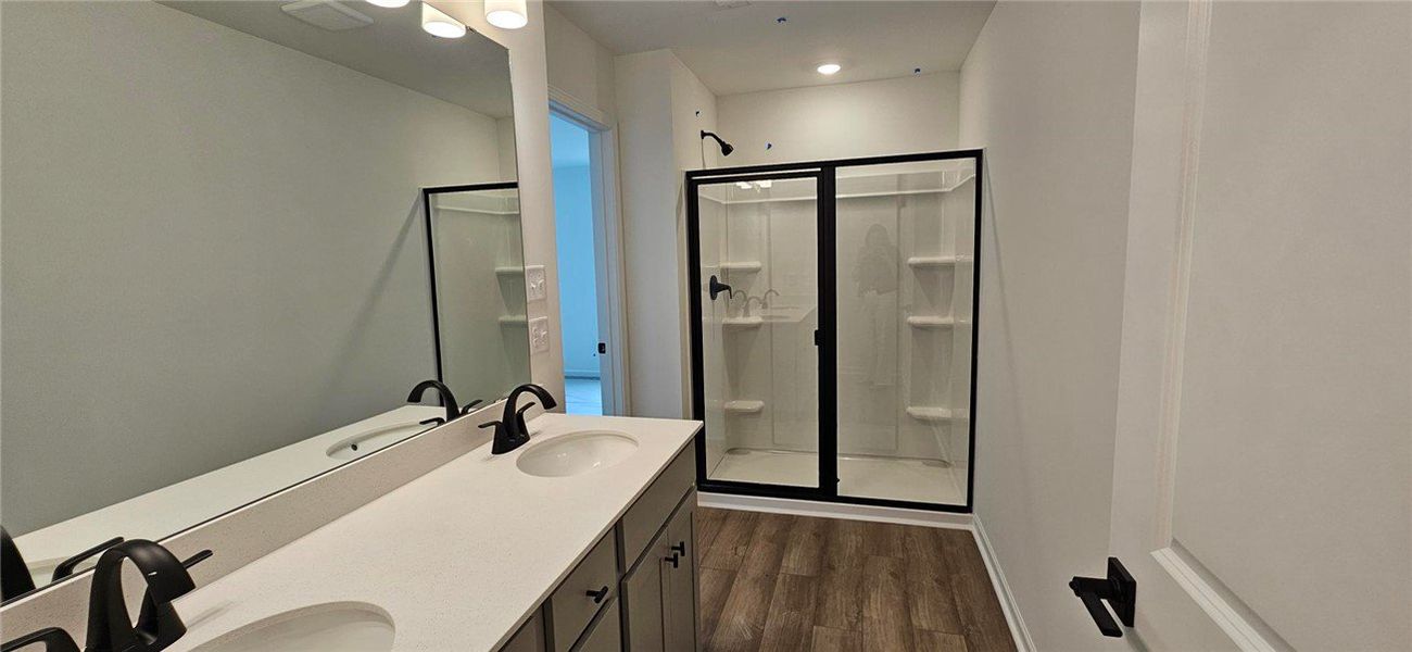 This modern bathroom features dual vanities and a