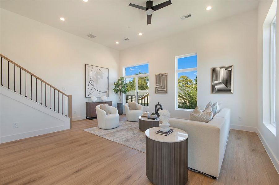 Living room with stairway, recessed lighting, light wood finished floors, and ceiling fan Living room with stairway, recessed lighting, light wood finished floors, and ceiling fan