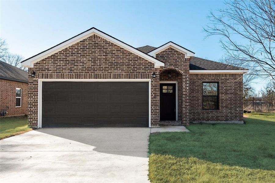 View of front facade with a garage and a front lawn