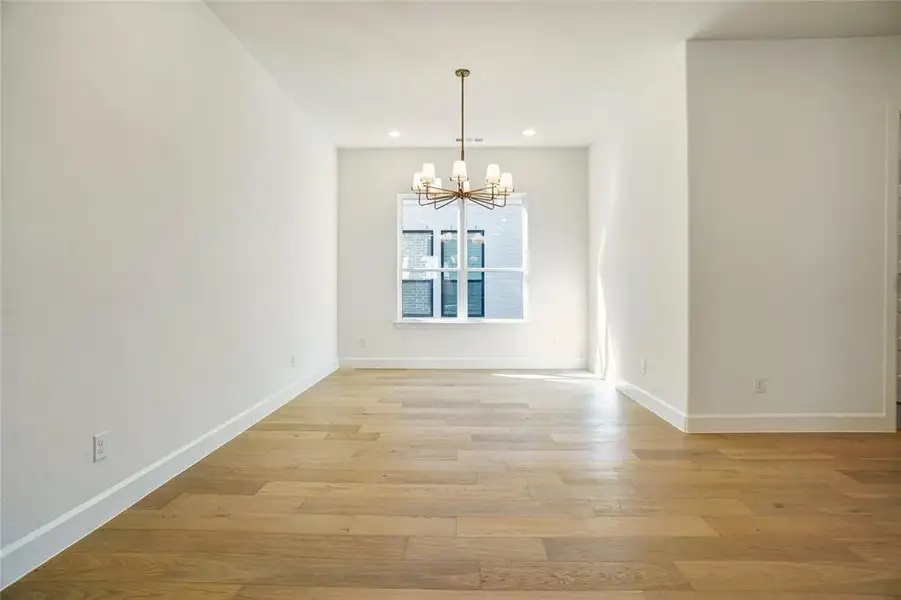 Unfurnished dining area with a chandelier, light wood-style flooring, and recessed lighting