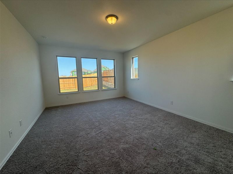 Carpeted spare room featuring baseboards