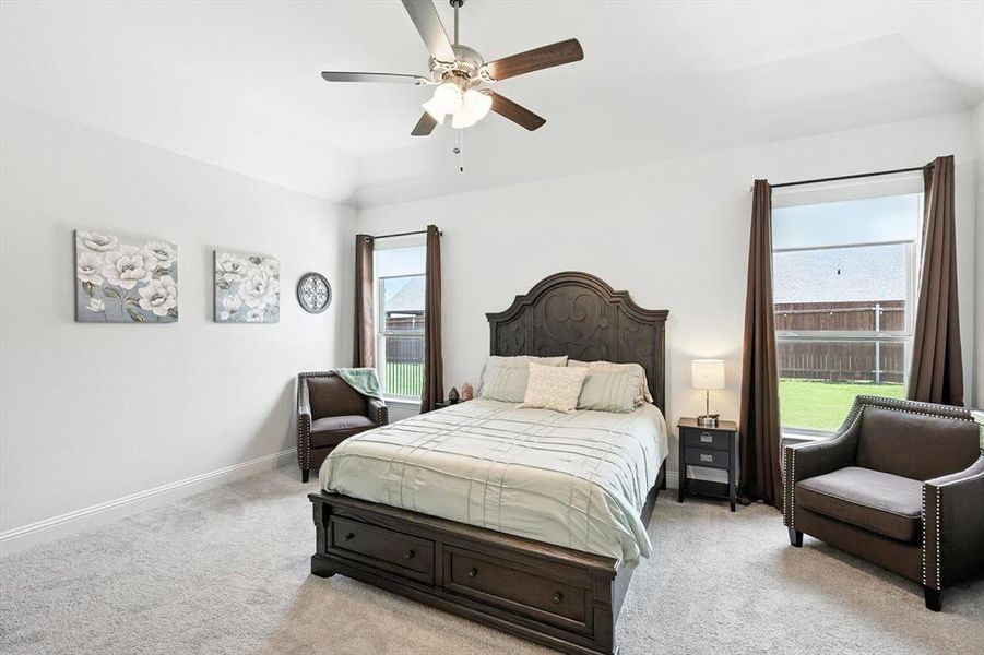 Bedroom featuring light colored carpet, a ceiling fan, and vaulted ceiling