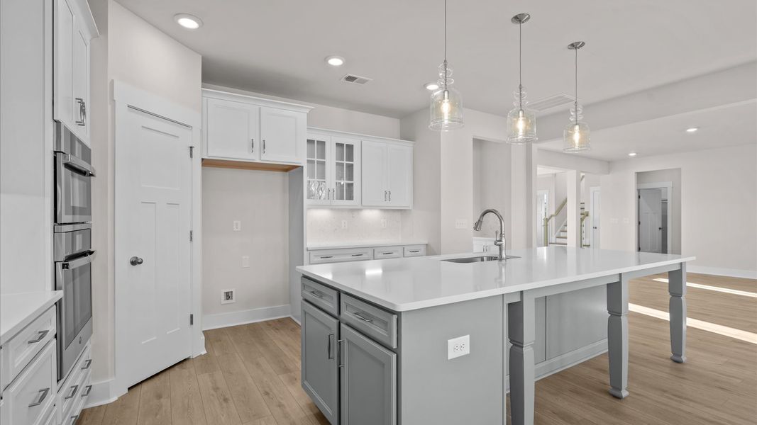 Tasteful kitchen with oversized island and stylish pendant lighting crafted to high standards