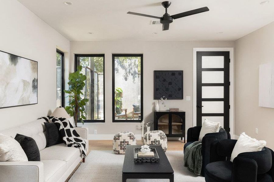 Living room featuring wood finished floors, ceiling fan, recessed lighting, and a fireplace Living room featuring wood finished floors, ceiling fan, recessed lighting, and a fireplace