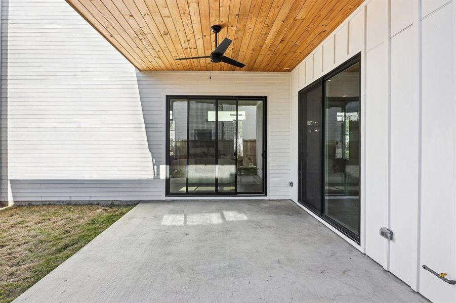 Doorway to property with ceiling fan and a patio