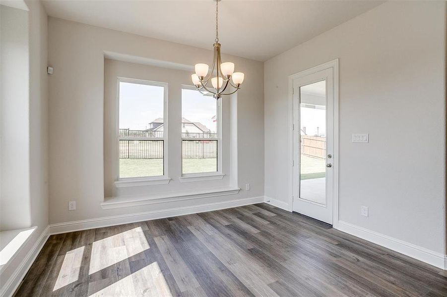 Unfurnished dining area featuring dark wood-type flooring and a chandelier