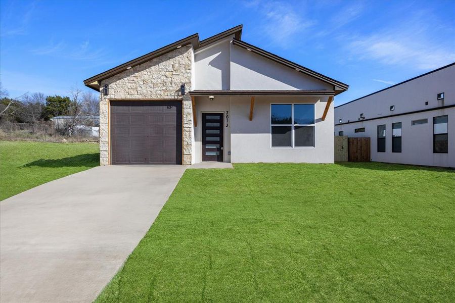 Contemporary house featuring a front yard and a garage