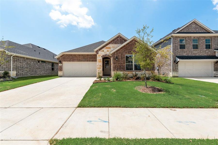Front exterior of a new home in Spiritas Ranch, Little Elm, TX, highlighting curb appeal (Image 19). Front exterior of a new home in Spiritas Ranch, Little Elm, TX, highlighting curb appeal (Image 19).