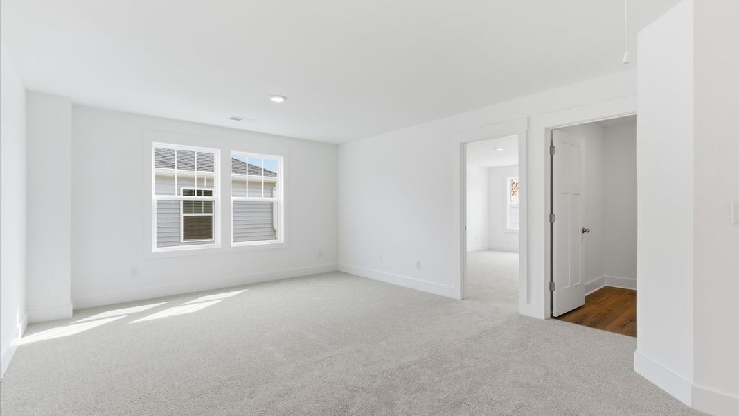 Vibrant carpeted loft offering flexibility as a study nook, game room, or second family space located in Gray Court, SC