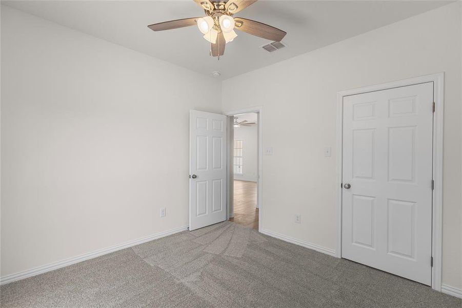 Unfurnished bedroom with carpet and a ceiling fan