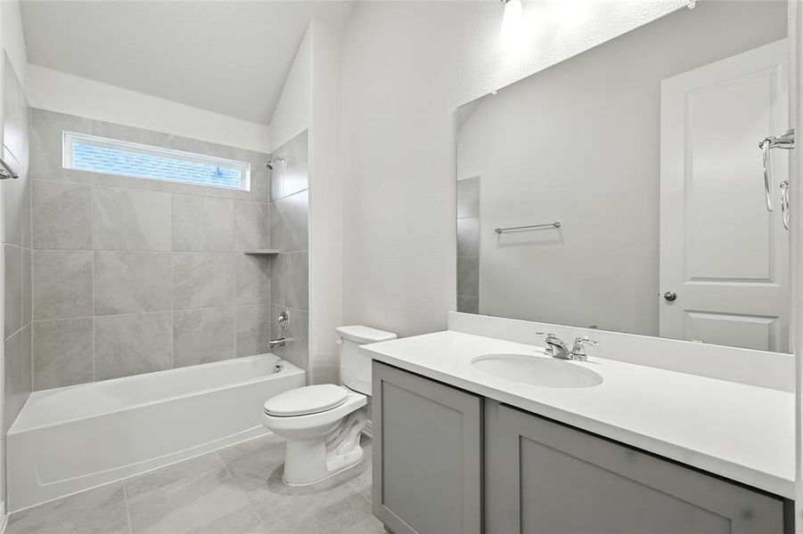 Bathroom with vanity, tub / shower combination, and lofted ceiling