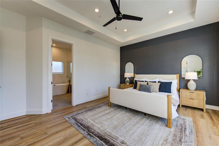 This oversized primary bedroom on the 3rd floor features a tray ceiling and tons of natural light. Includes two walk-in closets: one in the bedroom and the other in the bathroom.