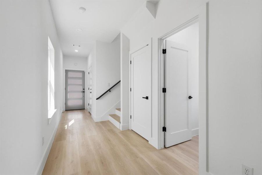 Hall with light wood-type flooring, recessed lighting, and stairs Hall with light wood-type flooring, recessed lighting, and stairs