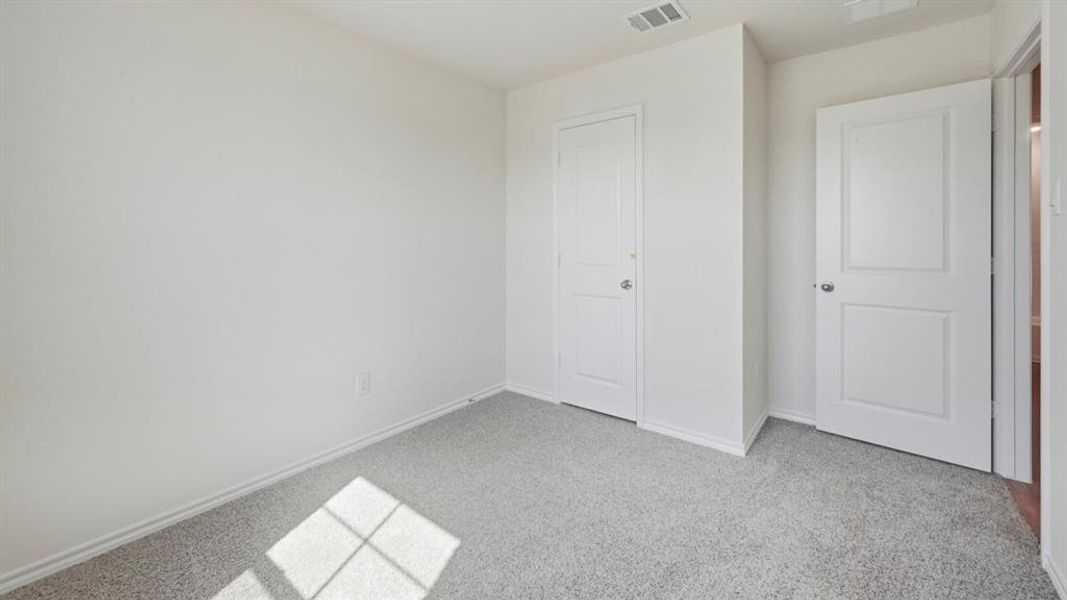 Unfurnished bedroom with light carpet and baseboards Unfurnished bedroom with light carpet and baseboards