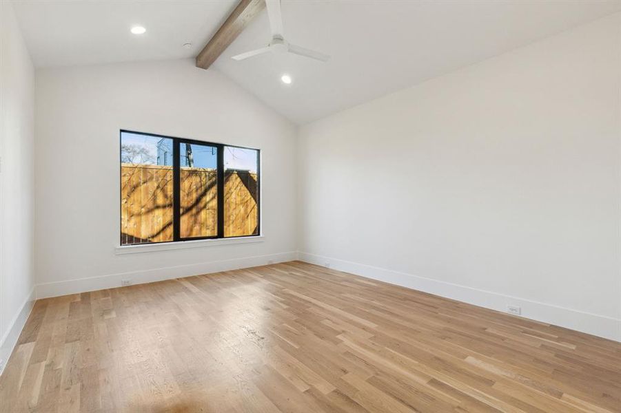 The Primary with vaulted ceiling with beams, light hardwood  and ceiling fan