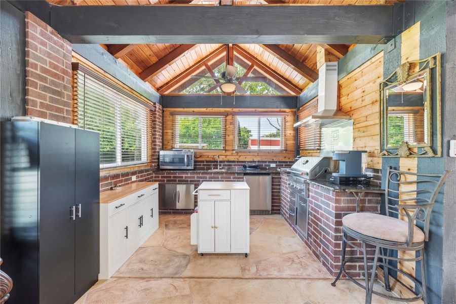 Custom men’s retreat featuring a full outdoor kitchen, rich wood detailing, and entertainer’s layout.