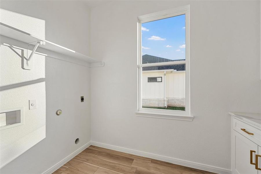 Laundry room featuring electric dryer hookup, light wood-style floors, washer hookup, and hookup for a gas dryer