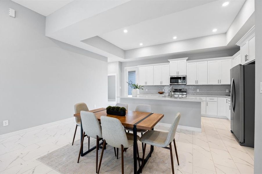 Expansive kitchen with plenty of cabinetry, a large island with a sink, and modern finishes