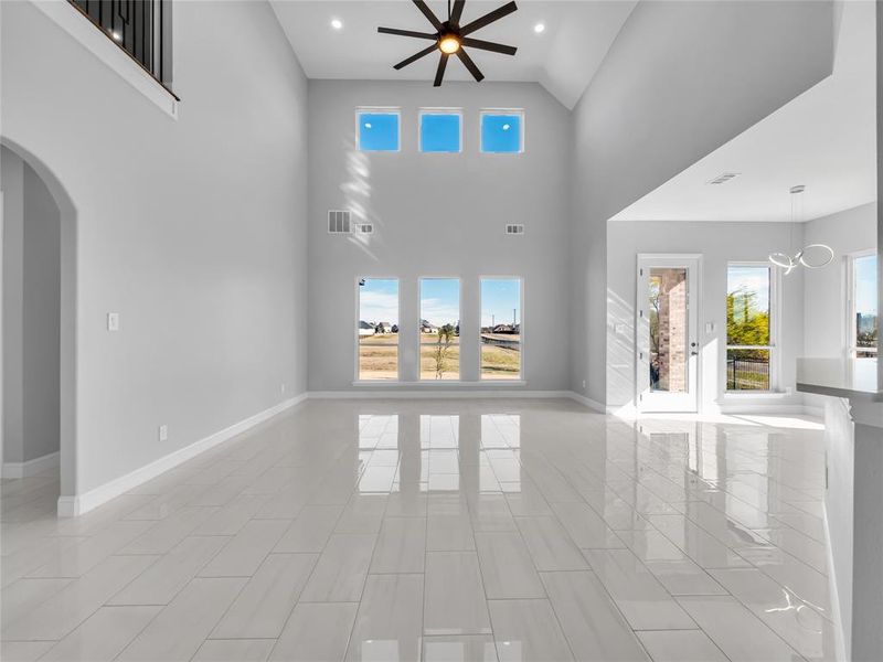 Oversized open living room with high ceilings, lots of natural light, and ceiling fan. Oversized open living room with high ceilings, lots of natural light, and ceiling fan.