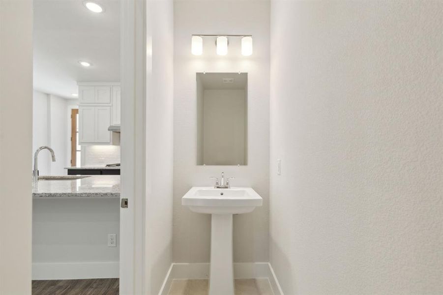 Powder Bathroom with recessed lighting, baseboards, a sink, and wood finished floors