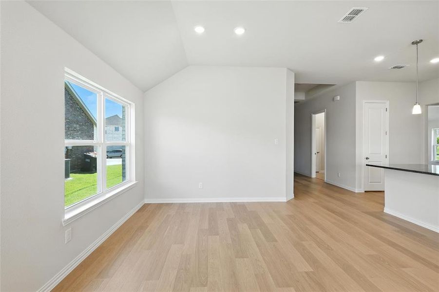 Unfurnished living room with light wood-style floors, recessed lighting, and lofted ceiling Unfurnished living room with light wood-style floors, recessed lighting, and lofted ceiling