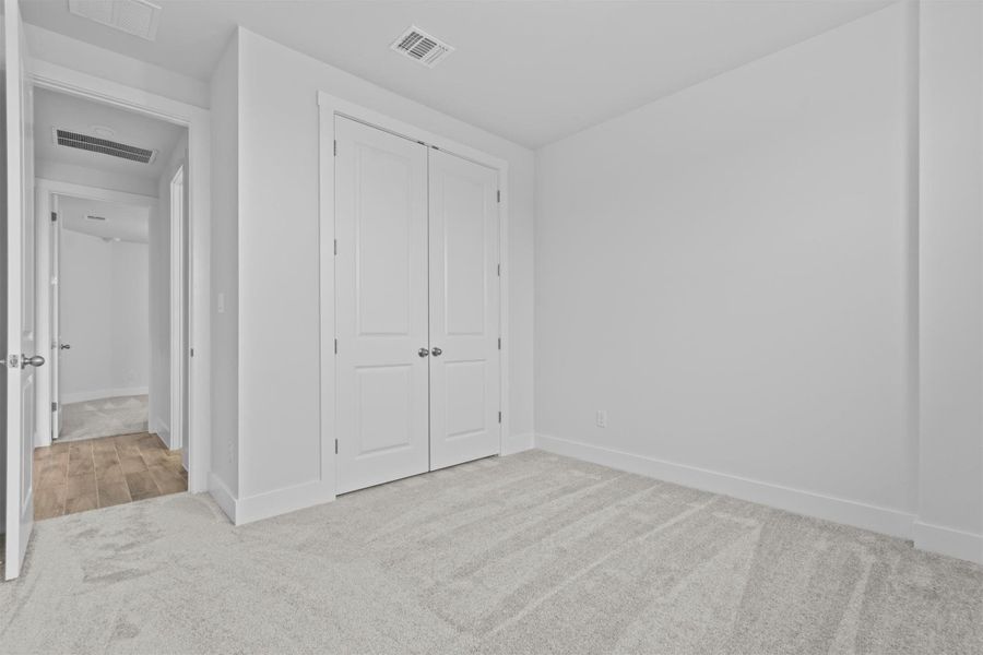 Unfurnished bedroom featuring a closet and light colored carpet