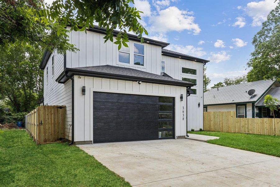 View of front of home with a front yard and a garage