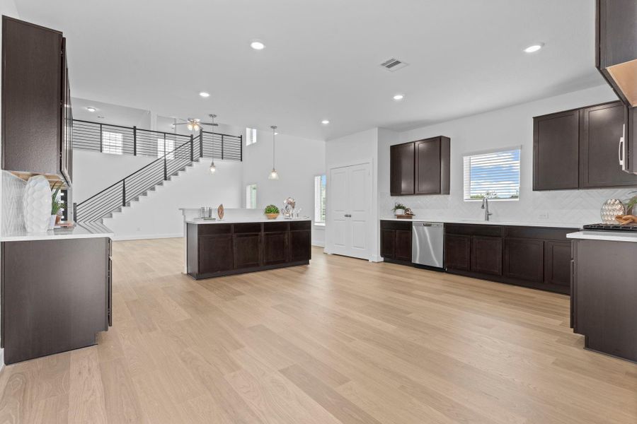 A reverse view of the open-concept layout emphasizes seamless sightlines from the kitchen into the family room, with abundant natural light and room for both entertaining and relaxation. **Image Representative of Plan Only and May Vary as Built**. A reverse view of the open-concept layout emphasizes seamless sightlines from the kitchen into the family room, with abundant natural light and room for both entertaining and relaxation. **Image Representative of Plan Only and May Vary as Built**.