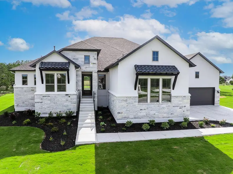 A modern facade with crisp white stucco and stacked stone accents, set against a vibrant green lawn. A modern facade with crisp white stucco and stacked stone accents, set against a vibrant green lawn.