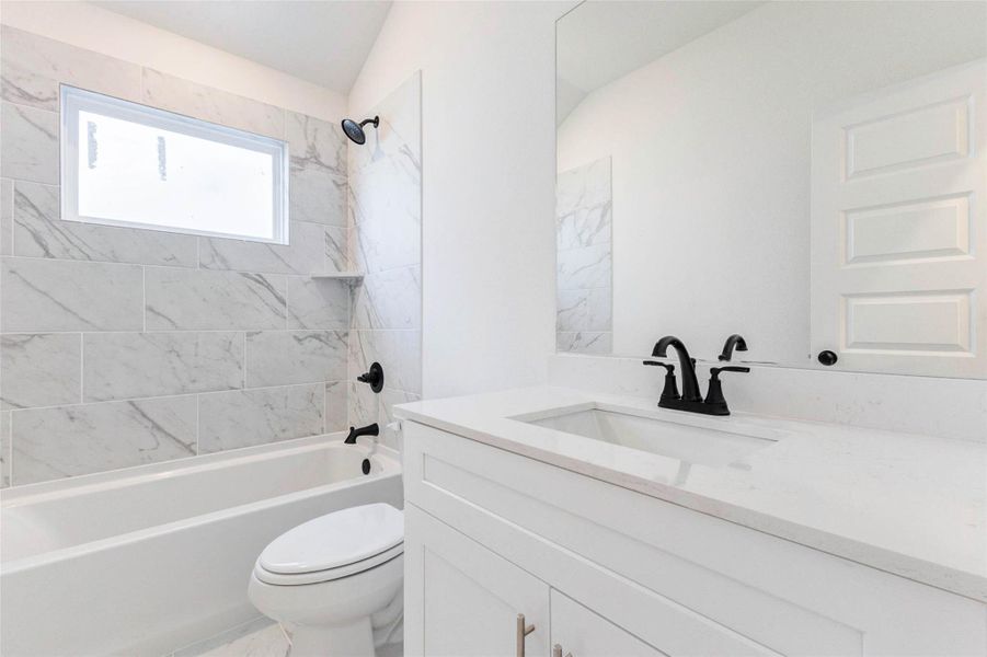 Full bath with double sinks and tub/shower combination serving secondary bedrooms.