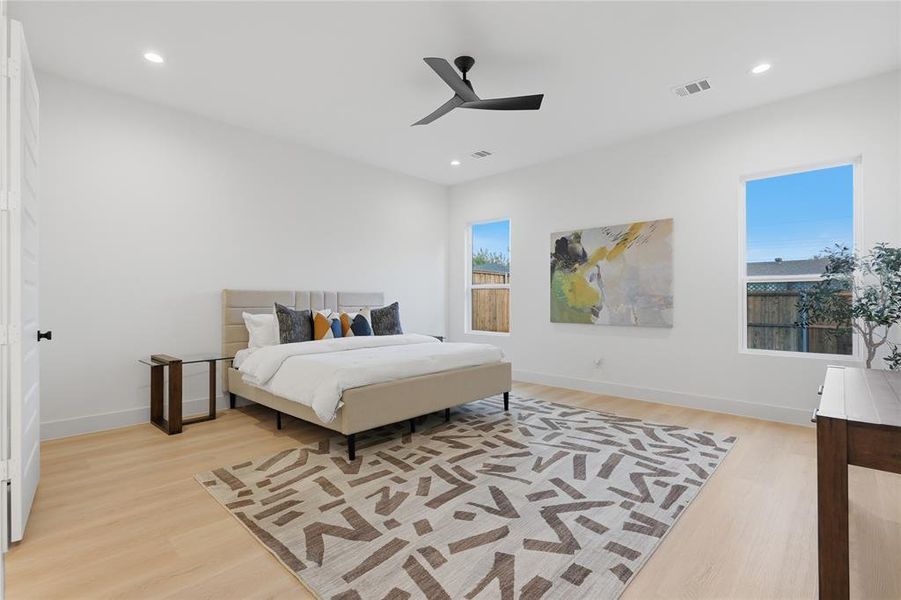 Spacious room featuring light wood-finish flooring, recessed lighting, and a modern ceiling fan