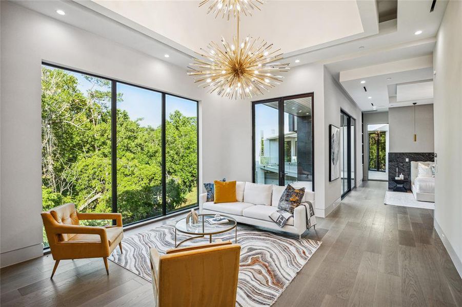 In this tranquil sanctuary within the primary bedroom retreat, glass doors beckon you to a spacious private terrace   perfect for serene moments of relaxation and stargazing. The ambiance is enhanced by the designer neutral wall paint and the warmth of stained White Oak Engineered Hardwood Flooring, while recessed LED lighting casts a soft glow, creating an atmosphere of comfort and serenity.