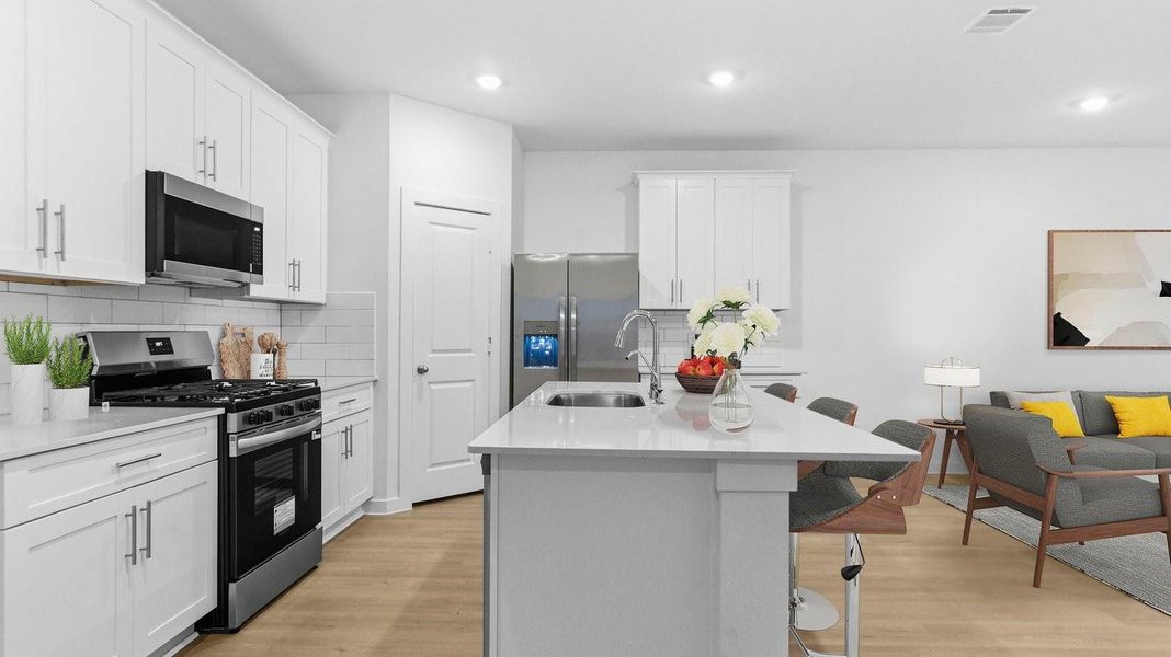 Kitchen adorned with white cabinets seamlessly integrated into an open dining area layout. Kitchen adorned with white cabinets seamlessly integrated into an open dining area layout.