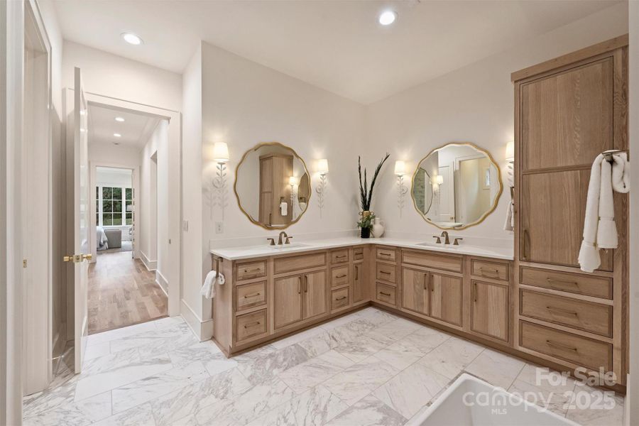 The primary bathroom offers a spa-like experience, making it a true retreat. The vanity, crafted from solid white oak, features inset cabinets and quartz countertops, offering ample storage.