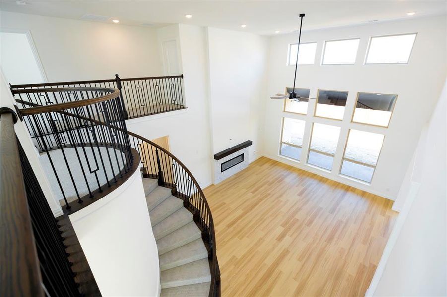 Stairway with plenty of natural light, wood finished floors, a high ceiling, recessed lighting, and ceiling fan Stairway with plenty of natural light, wood finished floors, a high ceiling, recessed lighting, and ceiling fan