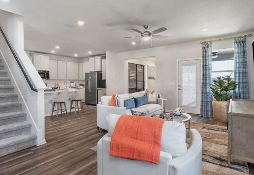 Living room featuring recessed lighting, stairway, dark wood-style flooring, and ceiling fan Living room featuring recessed lighting, stairway, dark wood-style flooring, and ceiling fan