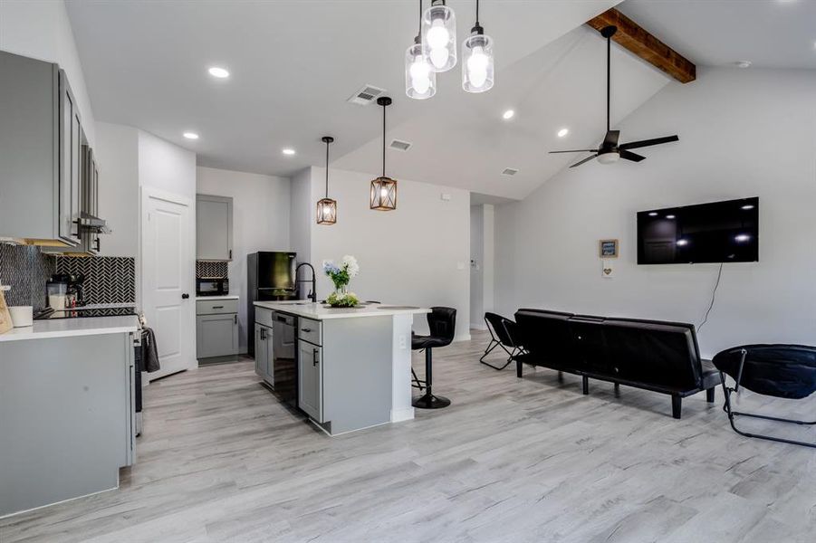 Kitchen with gray cabinets, tasteful backsplash, decorative light fixtures, recessed lighting, and light wood-style floors Kitchen with gray cabinets, tasteful backsplash, decorative light fixtures, recessed lighting, and light wood-style floors