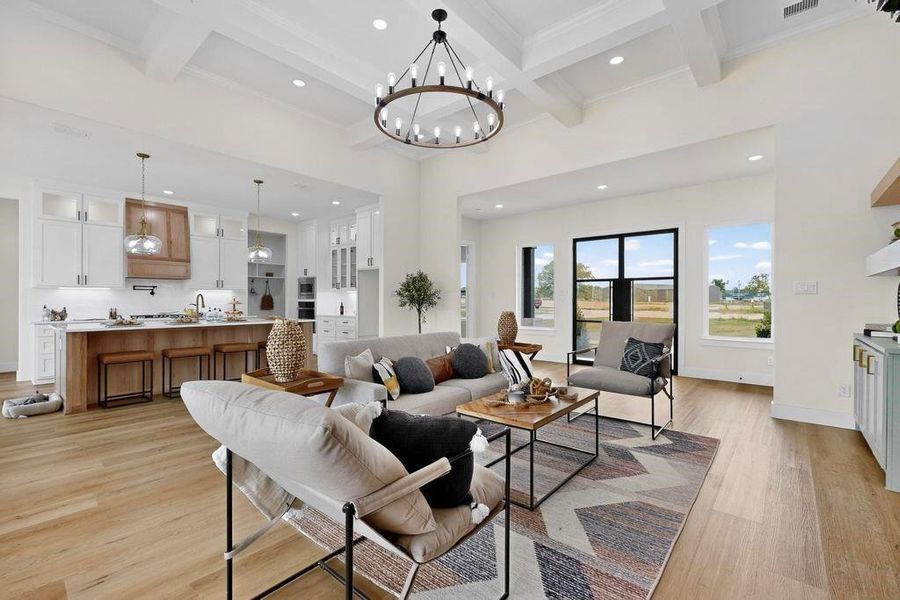 Living room featuring recessed lighting, beamed ceiling, light wood-style floors, coffered ceiling, and a chandelier Living room featuring recessed lighting, beamed ceiling, light wood-style floors, coffered ceiling, and a chandelier