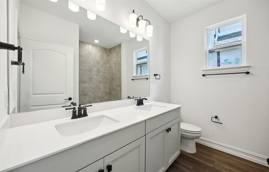 Upgraded secondary bathroom with dual vanity *real home pictured