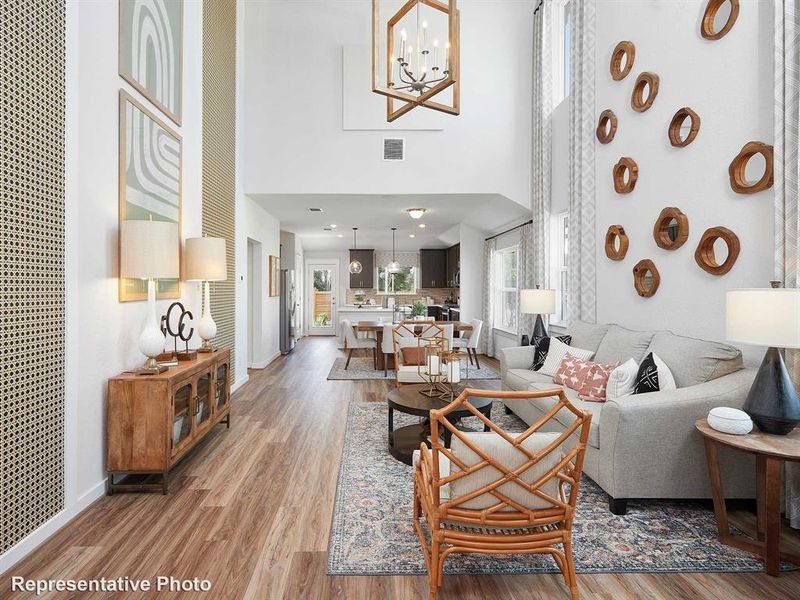 The property features an open-concept living area with high ceilings, hardwood-style flooring, and large windows providing abundant natural light