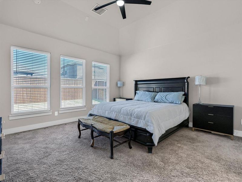 Bedroom featuring a high ceiling, carpet floors, and ceiling fan Bedroom featuring a high ceiling, carpet floors, and ceiling fan
