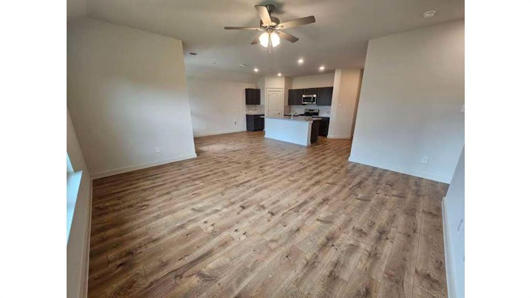 Spacious interior featuring wood-finish flooring, neutral wall tones, and recessed ceiling lighting