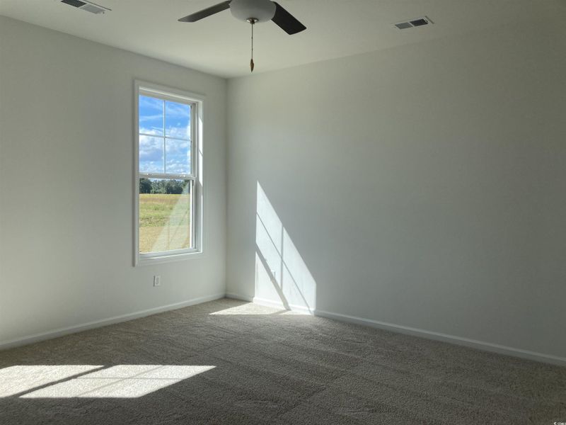 Unfurnished room with carpet flooring and a ceiling fan