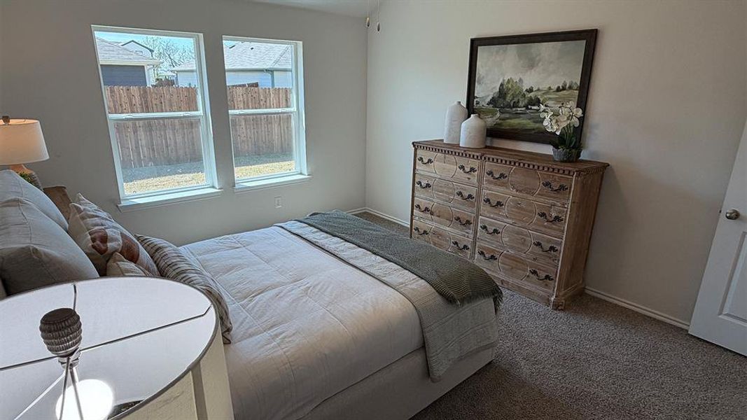 Bedroom featuring carpet and baseboards