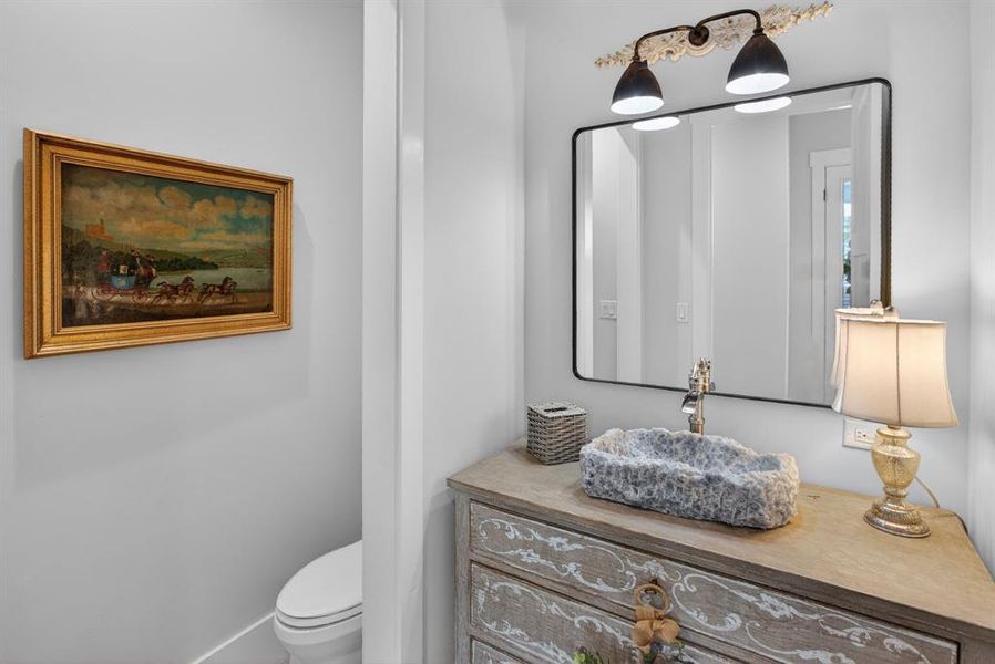 This half-bath is fabulous! The vintage French antique chest is complete with the hand-carved stone sink vessel. This is a one-of-a-kind feature.