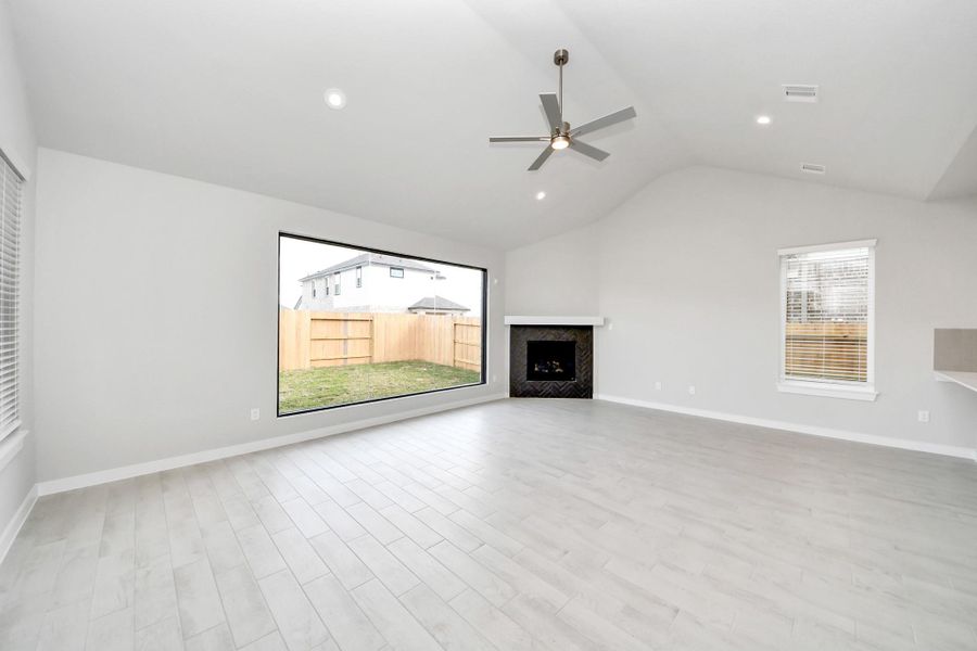 Family room flooded with natural light through the expansive windows.  The premium tile flooring adds a touch of luxury to the space, creating the perfect setting for relaxing moments and cherished gatherings with loved ones.