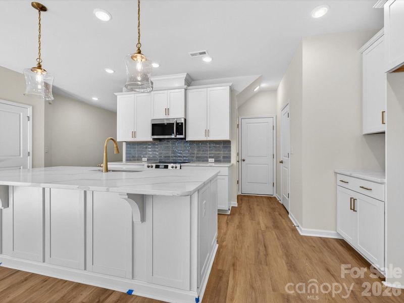 This bright and airy kitchen features an oversized kitchen Island. This bright and airy kitchen features an oversized kitchen Island.
