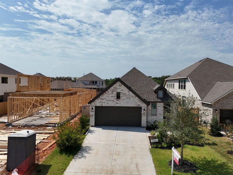 Charming single-story home with a stone façade and dark garage doors,